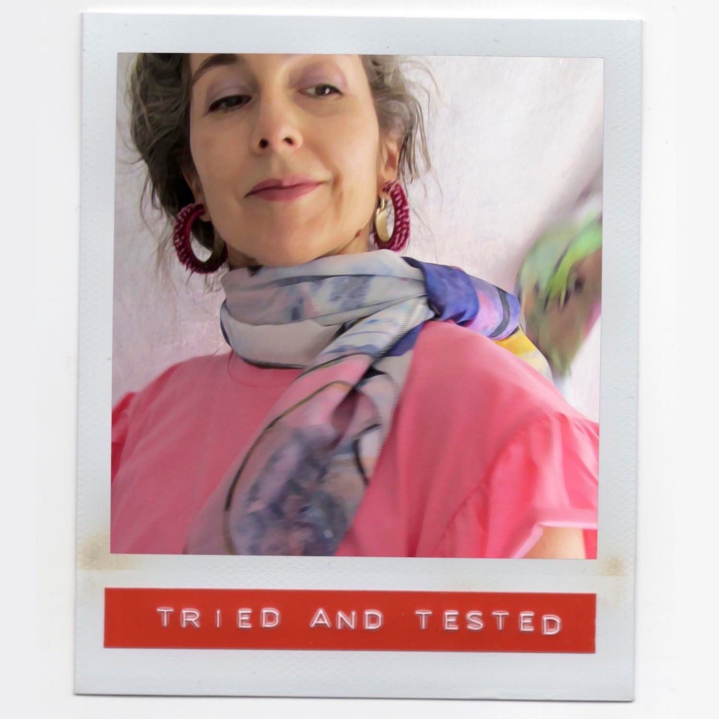 Alex Mitchell feeling fab wearing a chic multicolor large square scarf tied around her neck over pink top.