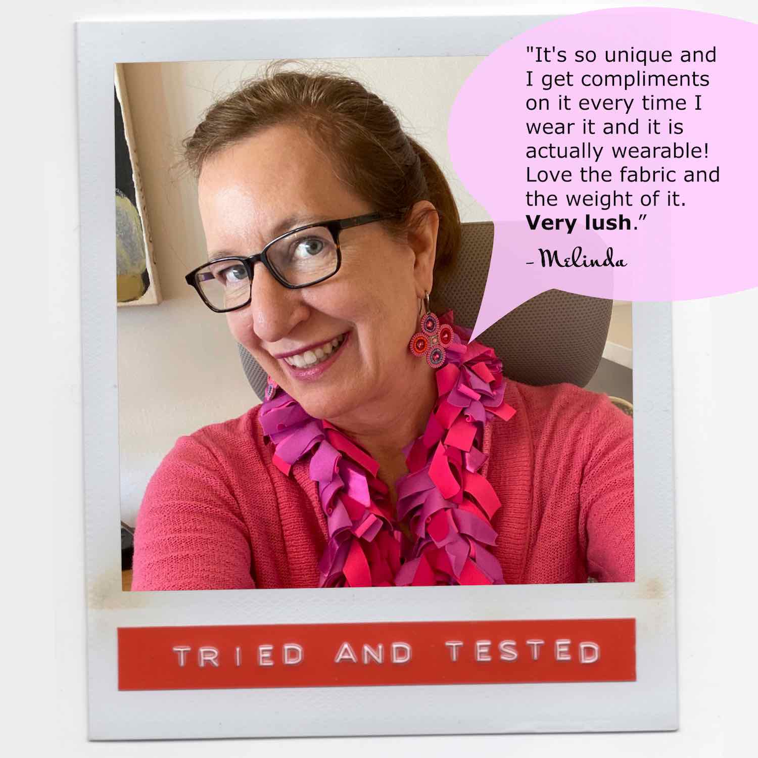Melinda working from home and feeling stylish in pink wearing her lush colorful fashion boa scarf.