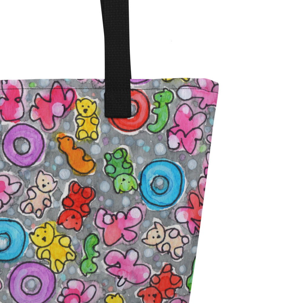 Close-up of black shoulder strap on multicolor Popcornfroops print on front of graphic tote bag.