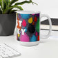 Colorful ceramic coffee mug with quirky slogan Just Ducky in white letters on Dripdrop design at white desk right view.