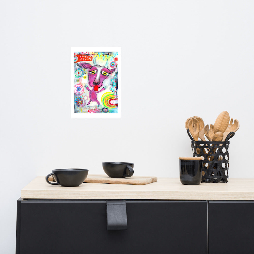 Colorful happy fine art print of a purple goat sticking out tongue on vibrant background hanging on wall at stylish counter.