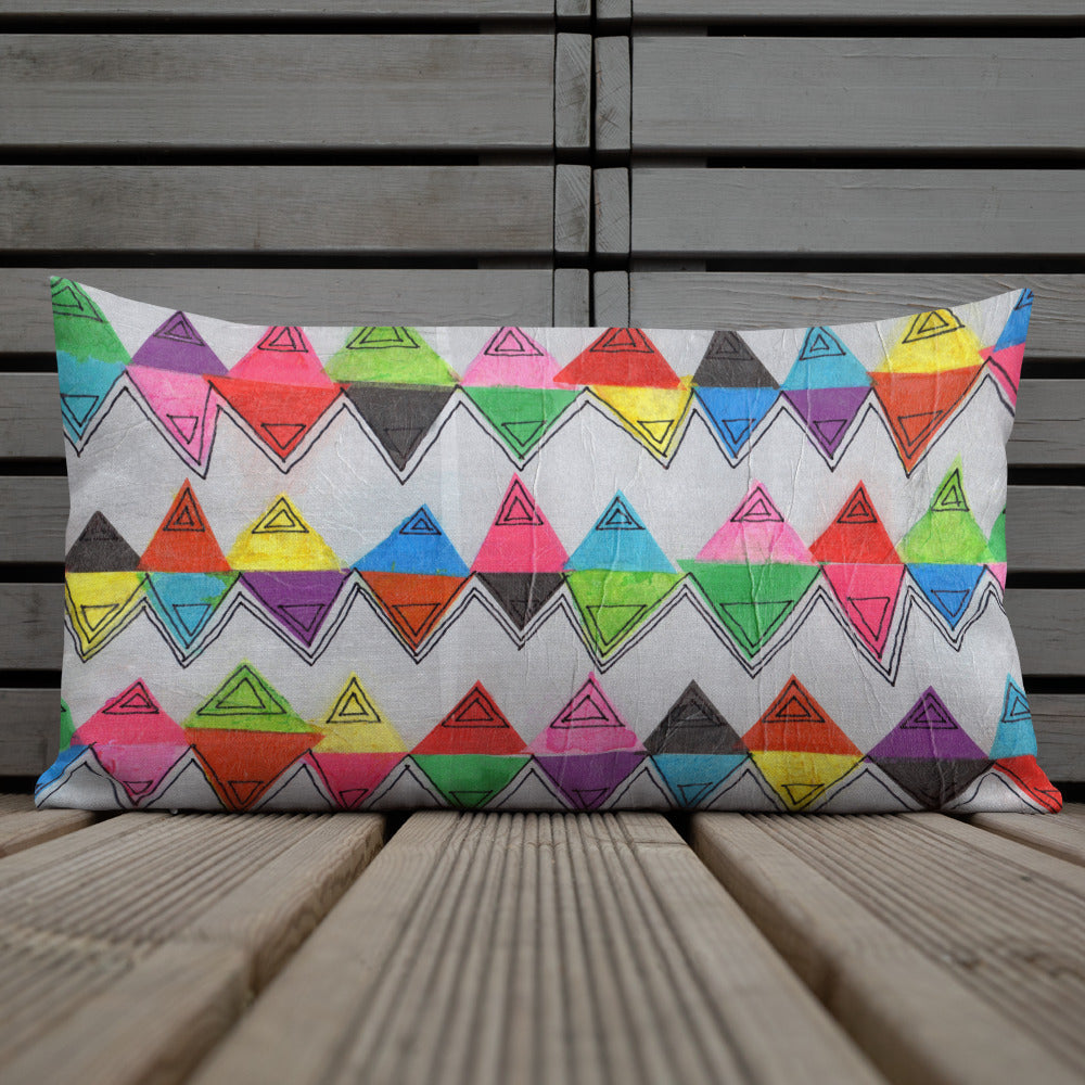 Vibrant, cheerful, and playful style accent pillow on wood deck with a multicolor graphic Zigzag print on front.