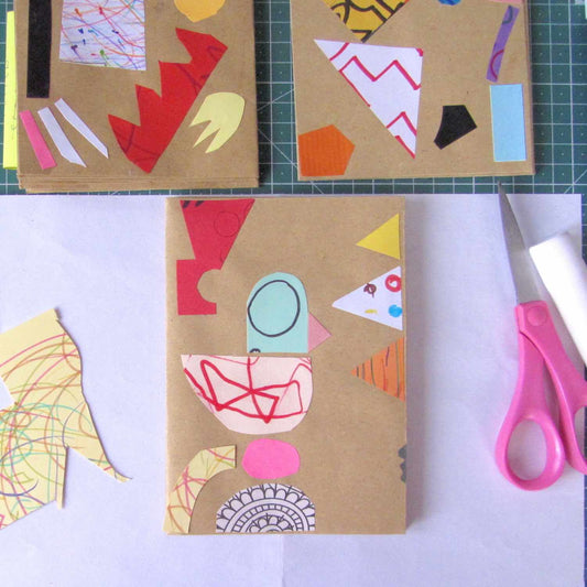Scissors, glue stick, and colorful paper cutouts of collage fodder used for making small playful collages on brown craft paper.