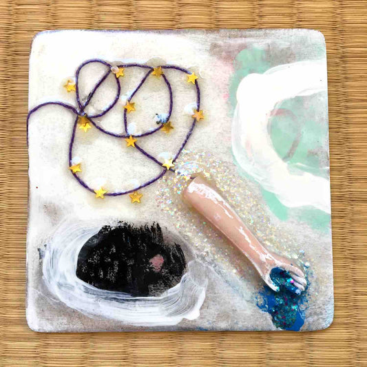 Square painting with doll arm, glitter puddle, and tiny gold stars on purple string by Alex Mitchell.