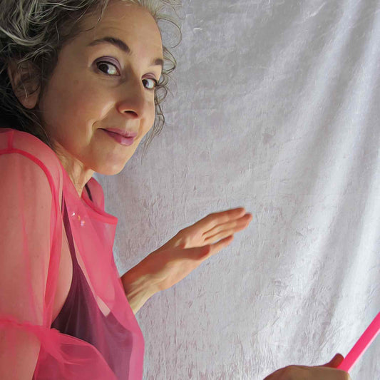 Funny self portrait of Alex Mitchell in pink tulle dress and magic fairy wand looking like she’s up to trouble.