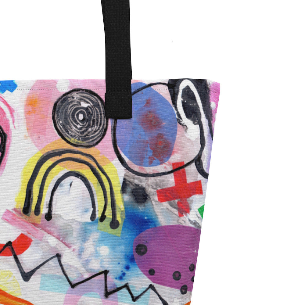 Close-up of black shoulder strap on multicolor Bazinga  print on front of graphic tote bag.