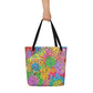 Big sturdy graphic tote bag with multicolor Macaroni print on front and black straps held by hand.