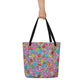 Big sturdy graphic tote bag with multicolor Popcornfroops print on front and black straps held by hand.