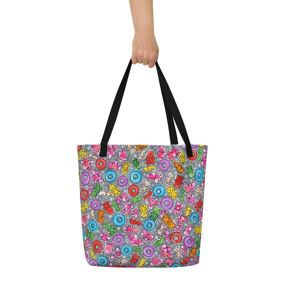 Big sturdy graphic tote bag with multicolor Popcornfroops print on front and black straps held by hand.