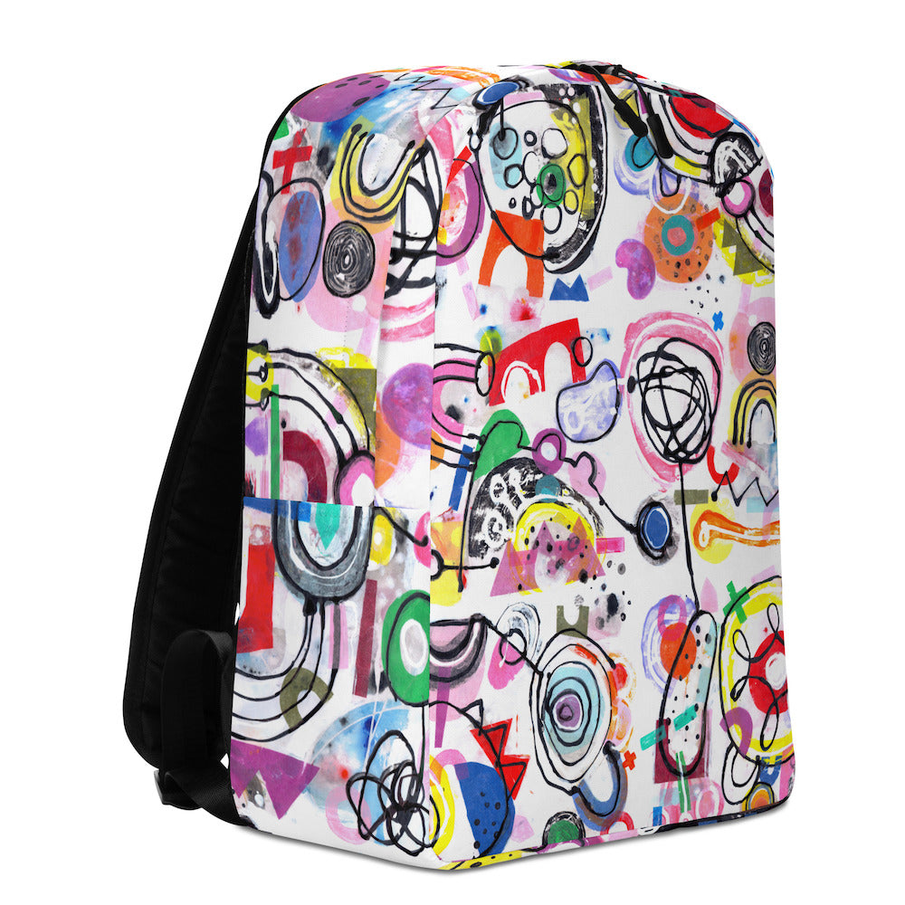 Graphic minimal design city style backpack with fun multicolor Treasure Map print and black shoulder straps, left side view.