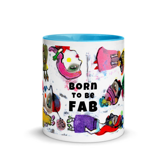 Graphic coffee mug with slogan Born To Be Fab and blue accent color on rim, handle and interior. Colorful Fab Ladies design, front view.