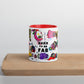 Graphic coffee mug with slogan Born To Be Fab and red accent color on rim and interior on wood counter front view.