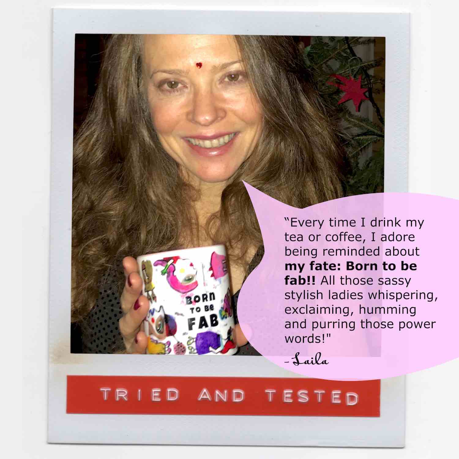 Laila smiling and holding her colorful coffee mug with slogan Born To Be Fab in black letters.