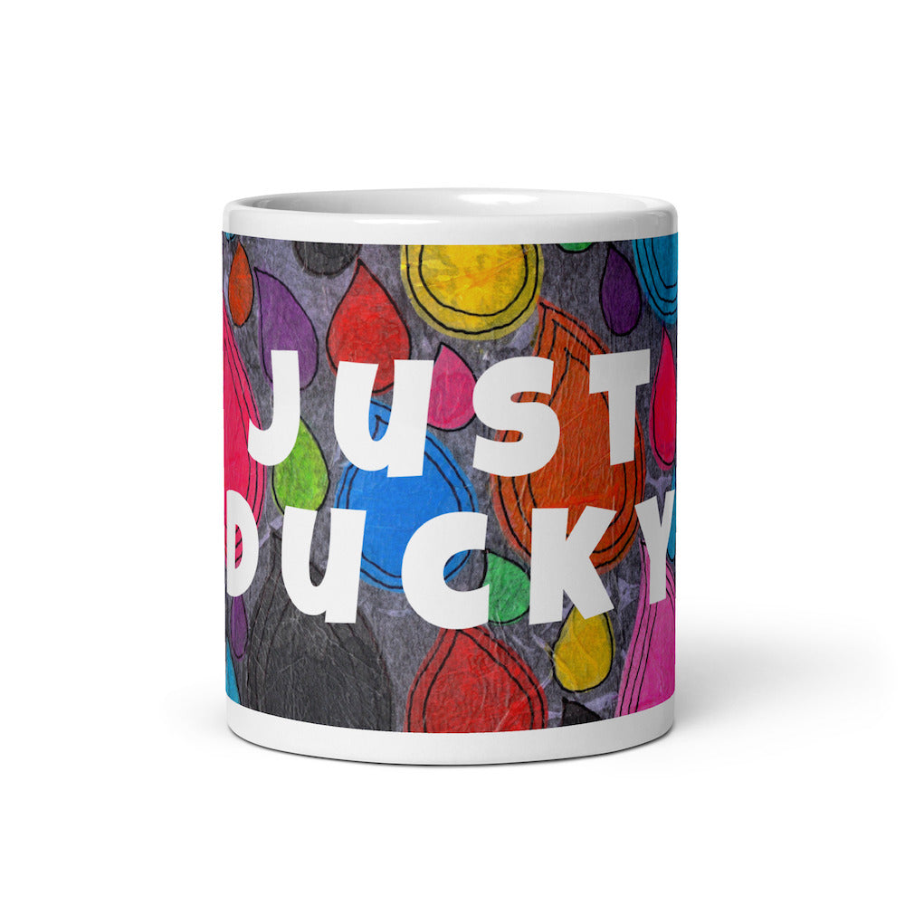 Colorful ceramic coffee mug with quirky slogan Just Ducky in white letters on Dripdrop design, front view of 11 ounce mug size.