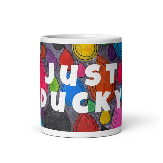 Colorful ceramic coffee mug with quirky slogan Just Ducky in white letters on Dripdrop design, front view of 11 ounce mug size.
