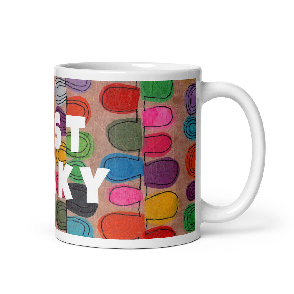 Colorful ceramic coffee mug with quirky slogan Just Ducky in white letters on v design, right handle view of 11 ounce mug size.