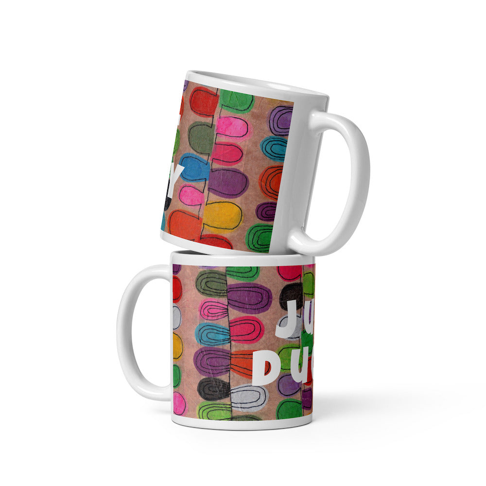 Two stacked colorful ceramic 11 ounce coffee mugs with quirky slogan Just Ducky in white letters on Flipflop design. 