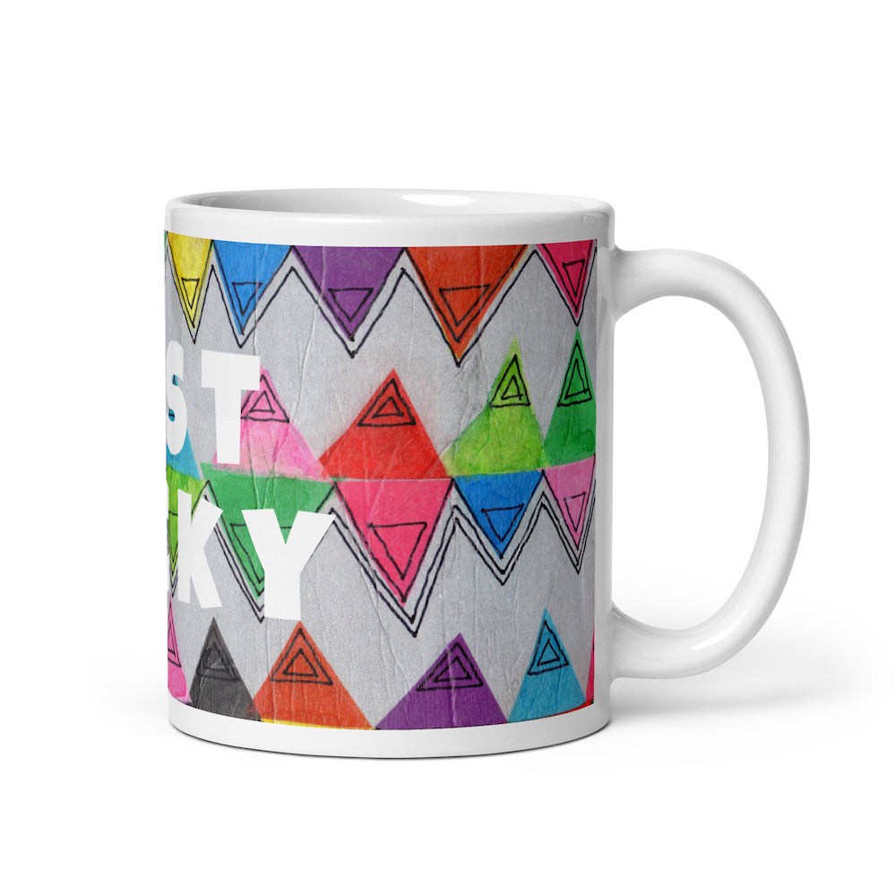 Colorful ceramic coffee mug with quirky slogan Just Ducky in white letters on Zigzag design, right handle view of 11 ounce mug size.