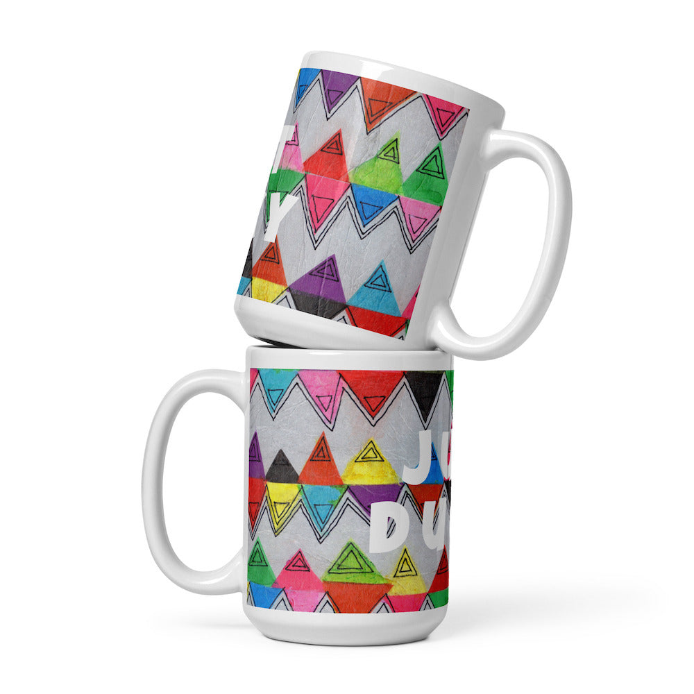 Two stacked colorful ceramic 15 ounce coffee mugs with quirky slogan Just Ducky in white letters on Zigzag design. 