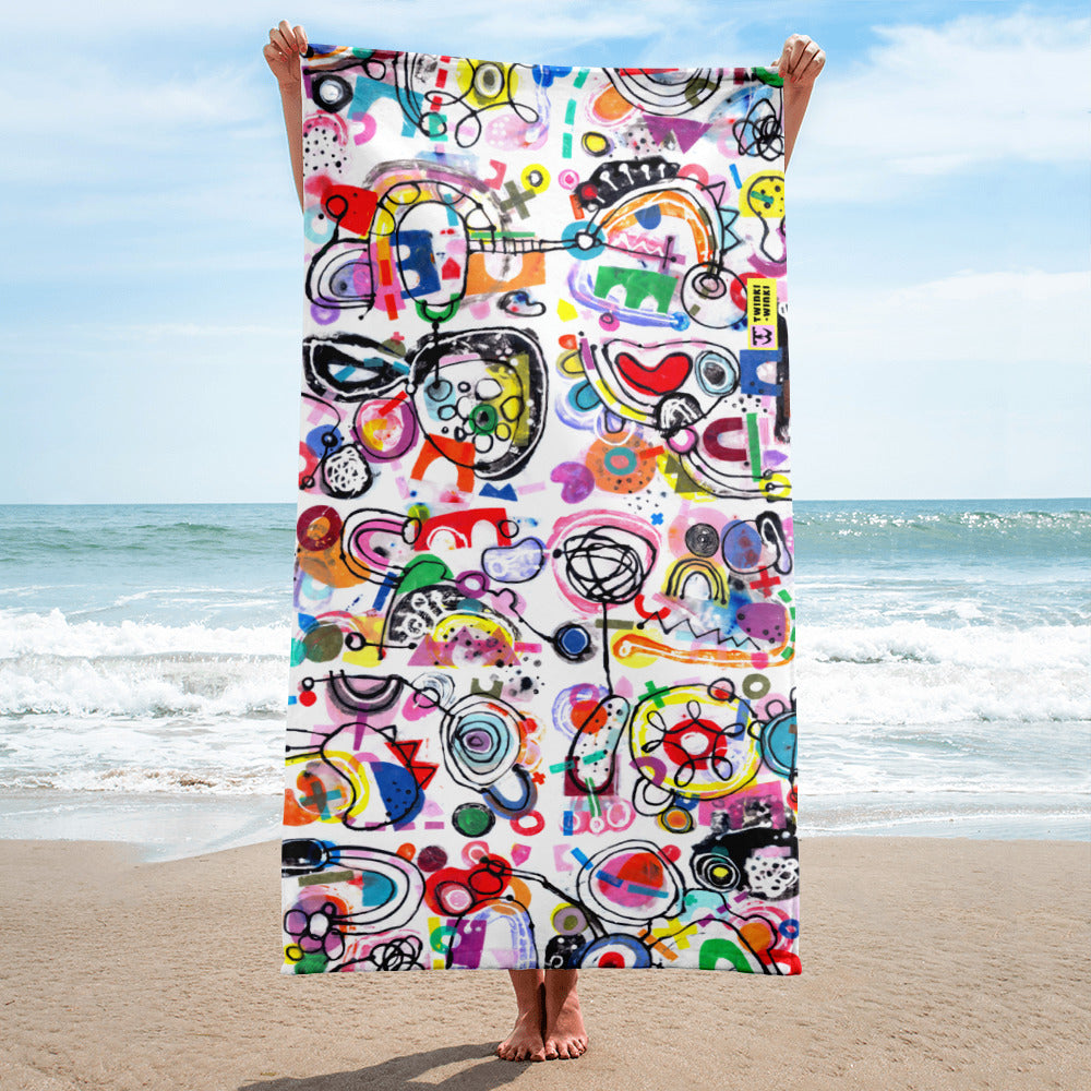 Stylish chic beach towel with bold multicolor Treasure Map print in a cheerful and playful style. Shown vertically and held by model.