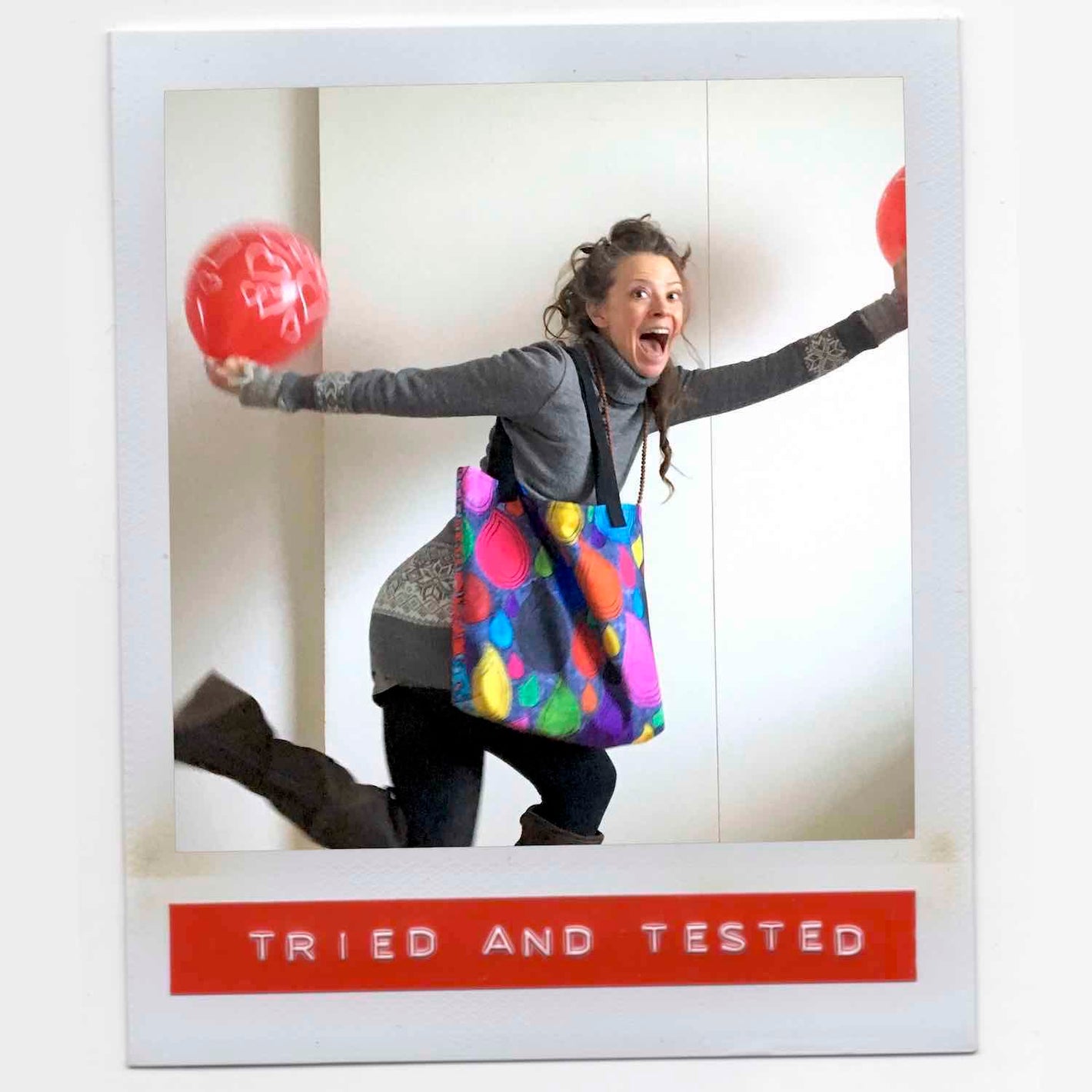 Laila all smiles and ready for takeoff wearing her playful pattern multicolor tote bag and holding colorful balloons.