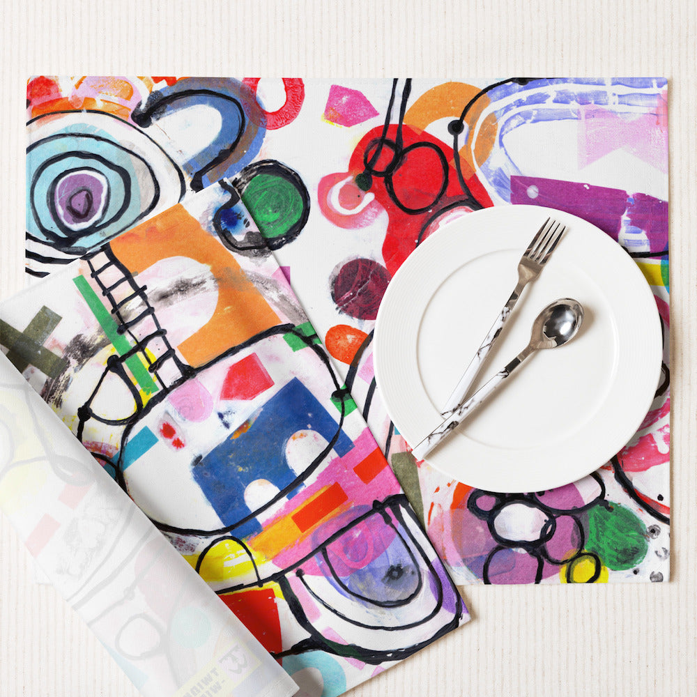 Arty graphic placemat set with happy multicolor Treasure Map print in a vibrant, cheerful, and playful style, with white plate.