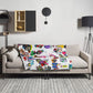 Stylish cozy graphic throw blanket with happy multicolor Fab Ladies print in a vibrant, cheerful, and playful style on beige sofa.
