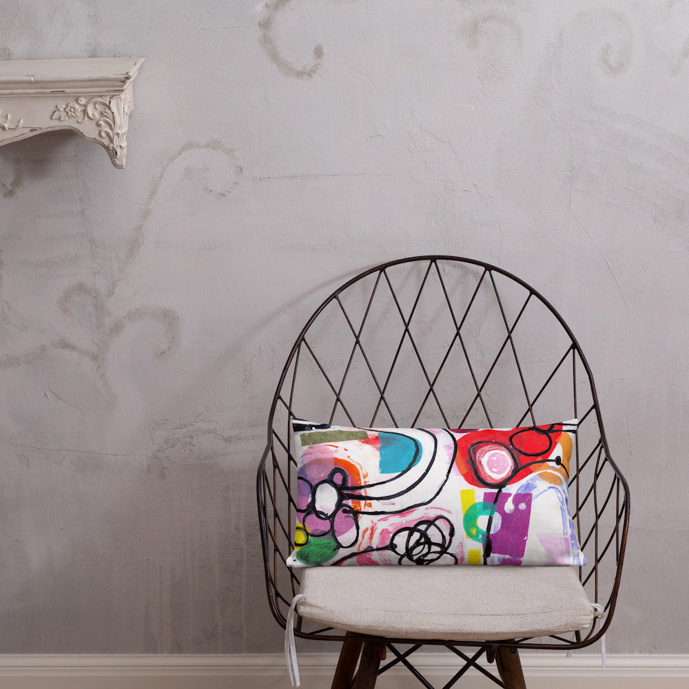 Vibrant, cheerful, and playful style accent pillow on modern chair with a multicolor graphic Euphoria print on front.