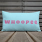 Vibrant, cheerful, and playful style accent pillow on wood deck with a fun Whoopee slogan in pink letters on cyan.