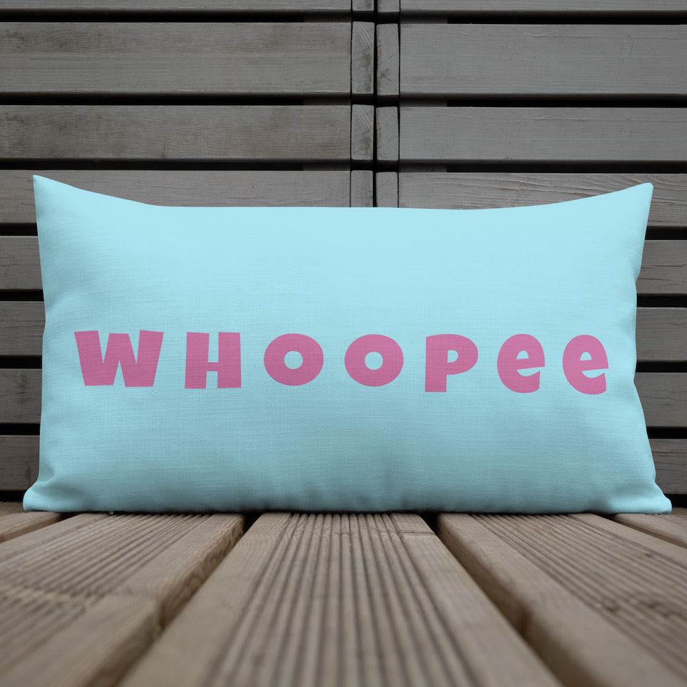 Vibrant, cheerful, and playful style accent pillow on wood deck with a fun Whoopee slogan in pink letters on cyan.