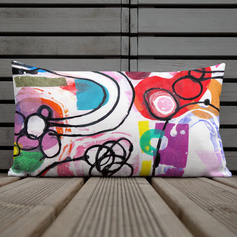 Vibrant, cheerful, and playful style accent pillow on wood deck with a multicolor graphic Euphoria print on front.