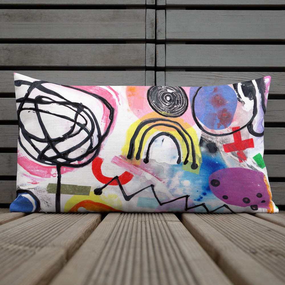 Vibrant, cheerful, and playful style accent pillow on wood deck with a multicolor graphic Eureka print on front.