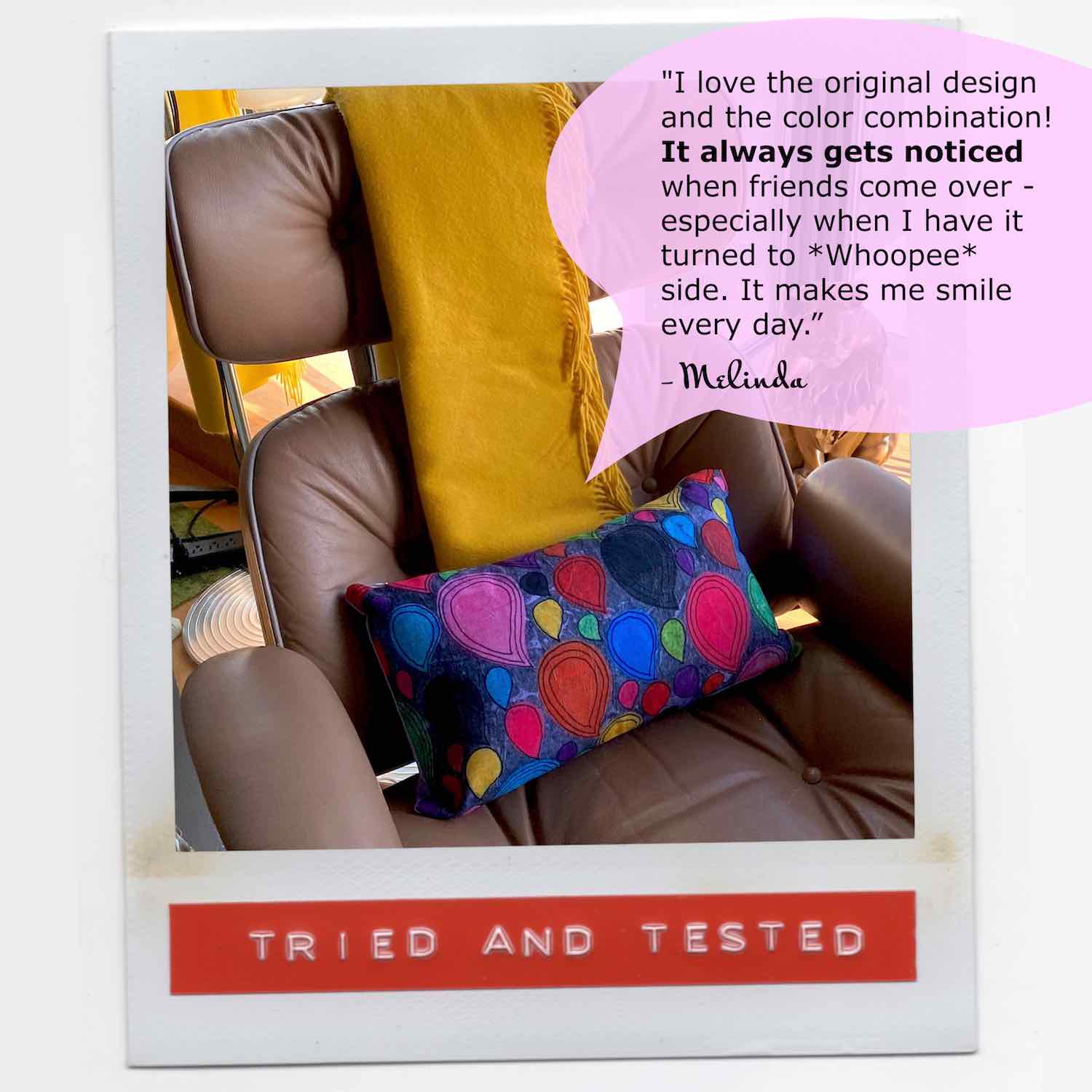 Stylish, cozy, colorful accent pillow on brown chair and yellow blanket with a happy graphic print.