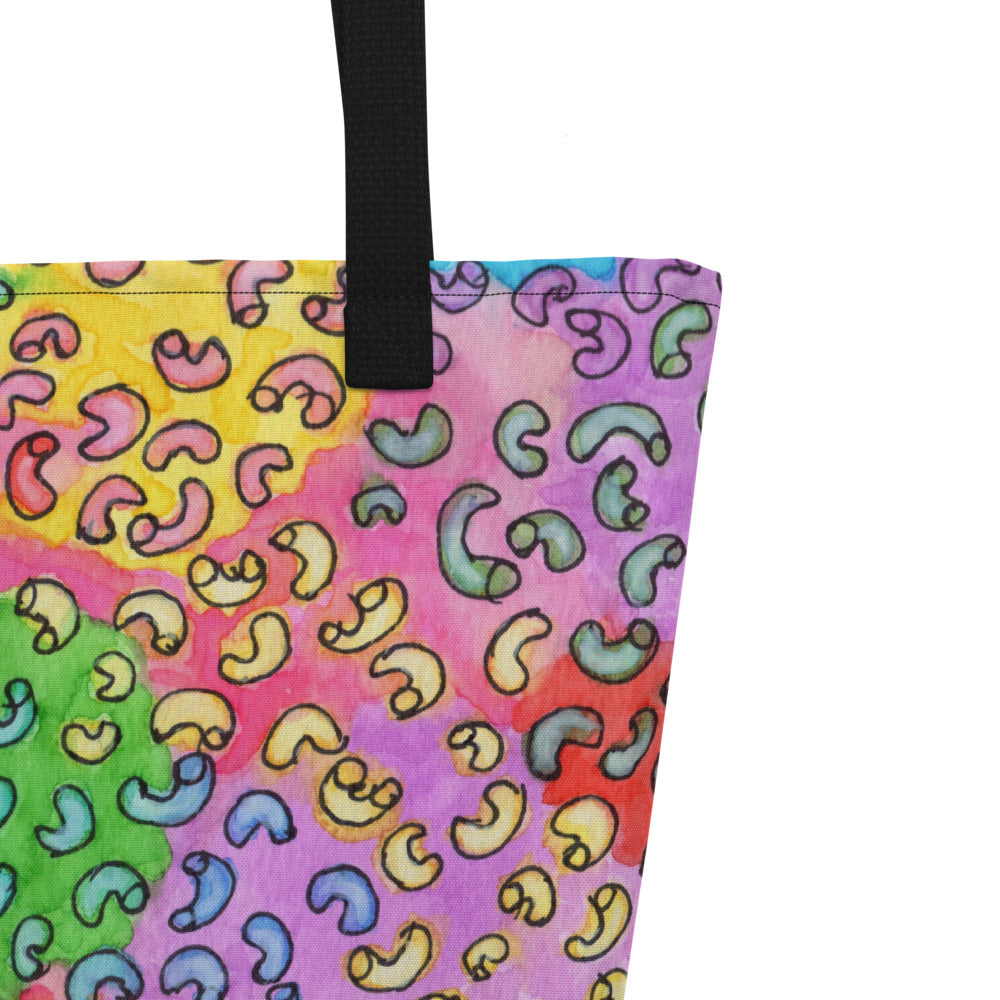 Close-up of black shoulder strap on multicolor Macaroni print on front of graphic tote bag.
