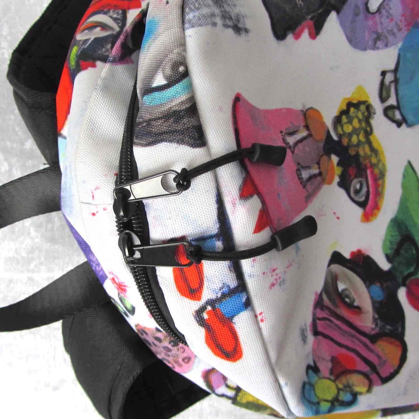 Detail of graphic minimal design city style backpack with fun multicolor Fab Ladies print and black zipper pulls.