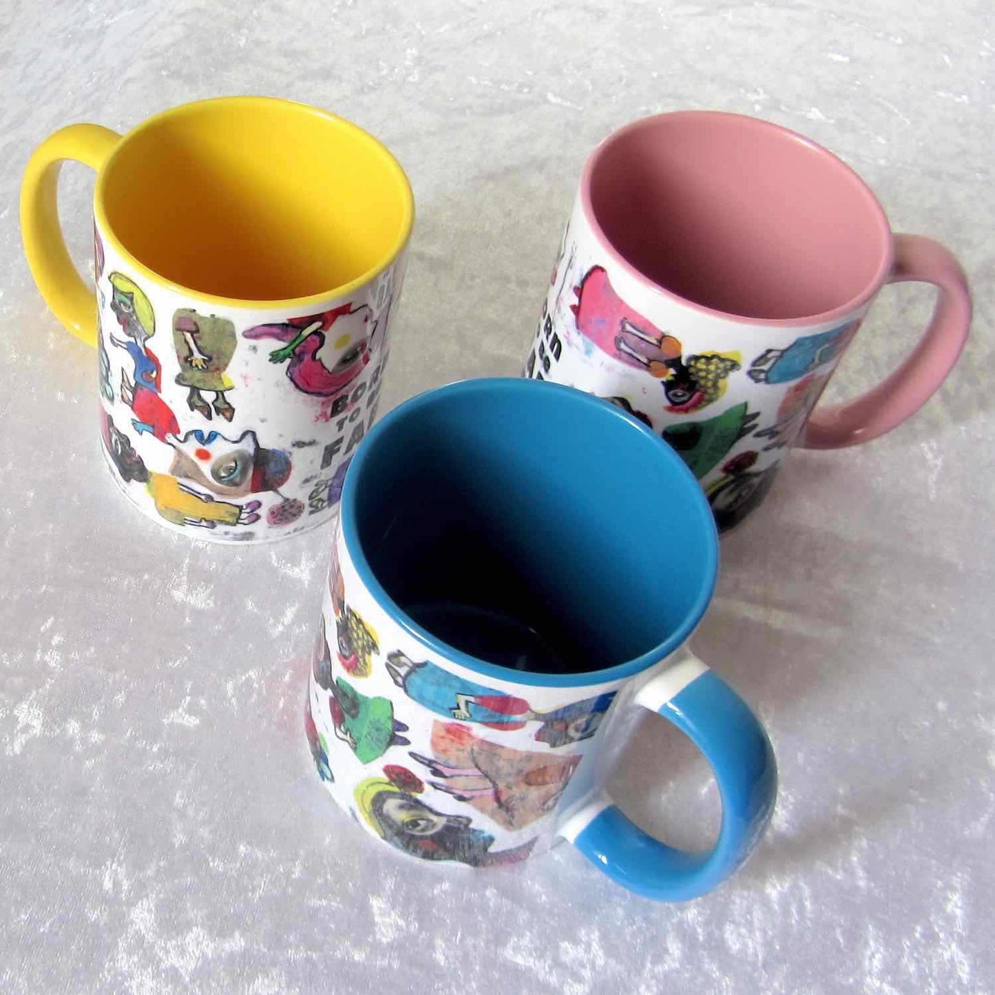Graphic coffee mugs with pink, blue, and yellow accent colors on rim, handle and interior. Colorful Fab Ladies design.
