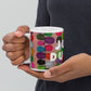 Colorful ceramic coffee mug with quirky slogan Just Ducky in white letters on Flipflop design, hands holding left view.