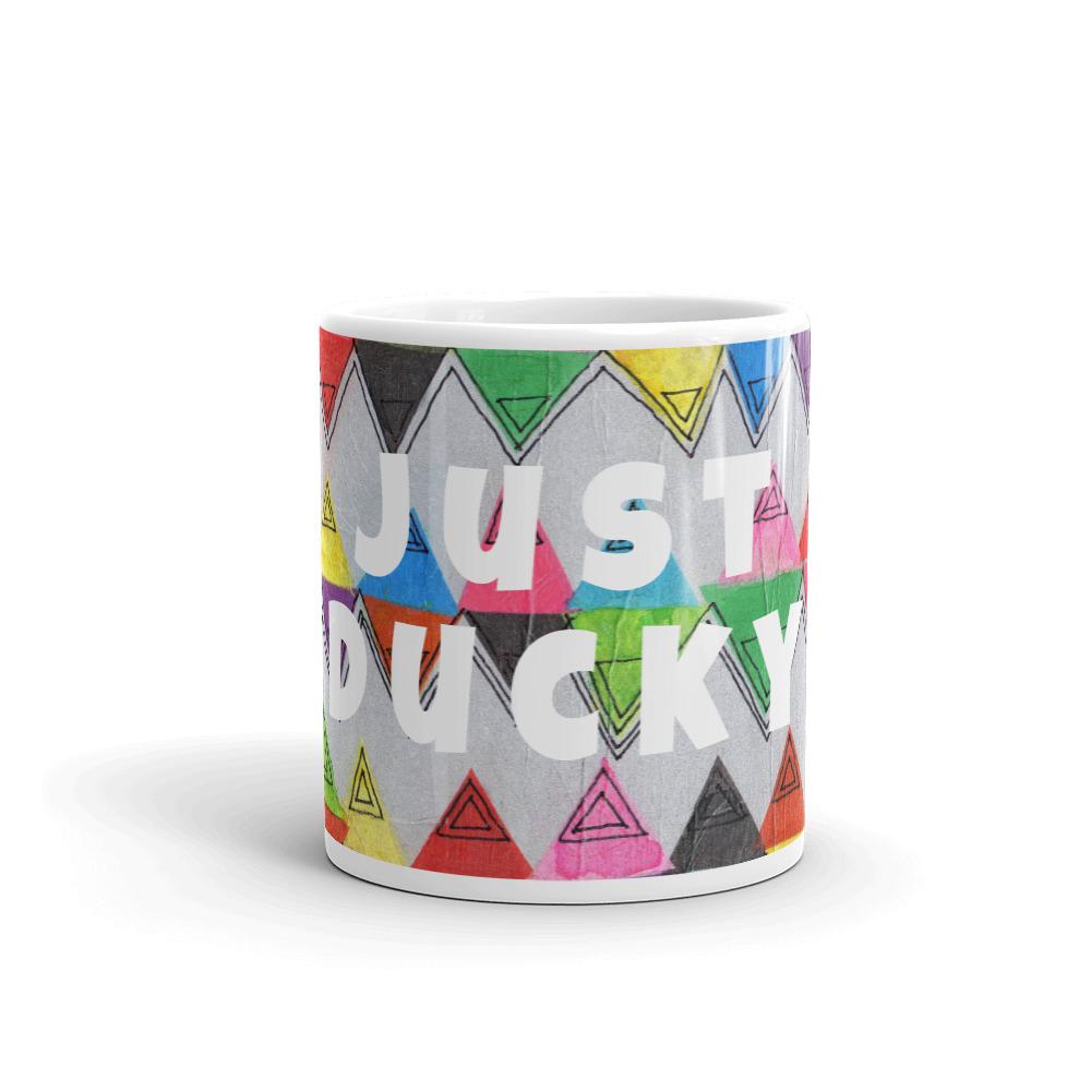 Colorful ceramic coffee mug with quirky slogan Just Ducky in white letters on Zigzag design, front view of 11 ounce mug size.