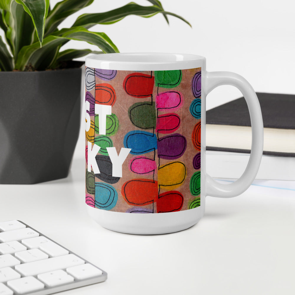 Colorful ceramic coffee mug with quirky slogan Just Ducky in white letters on Flipflop design at white desk right view.