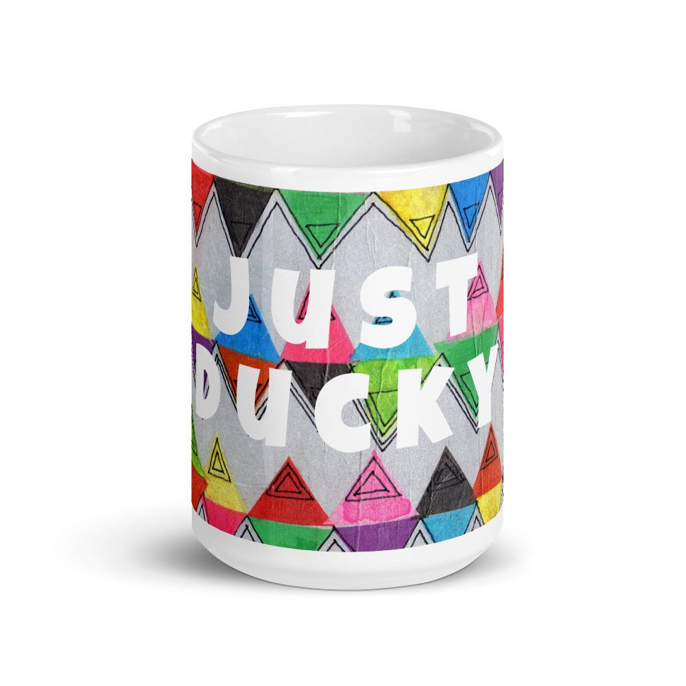 Big colorful ceramic coffee mug with quirky slogan Just Ducky in white letters on Zigzag design, front view of 15 ounce mug size.