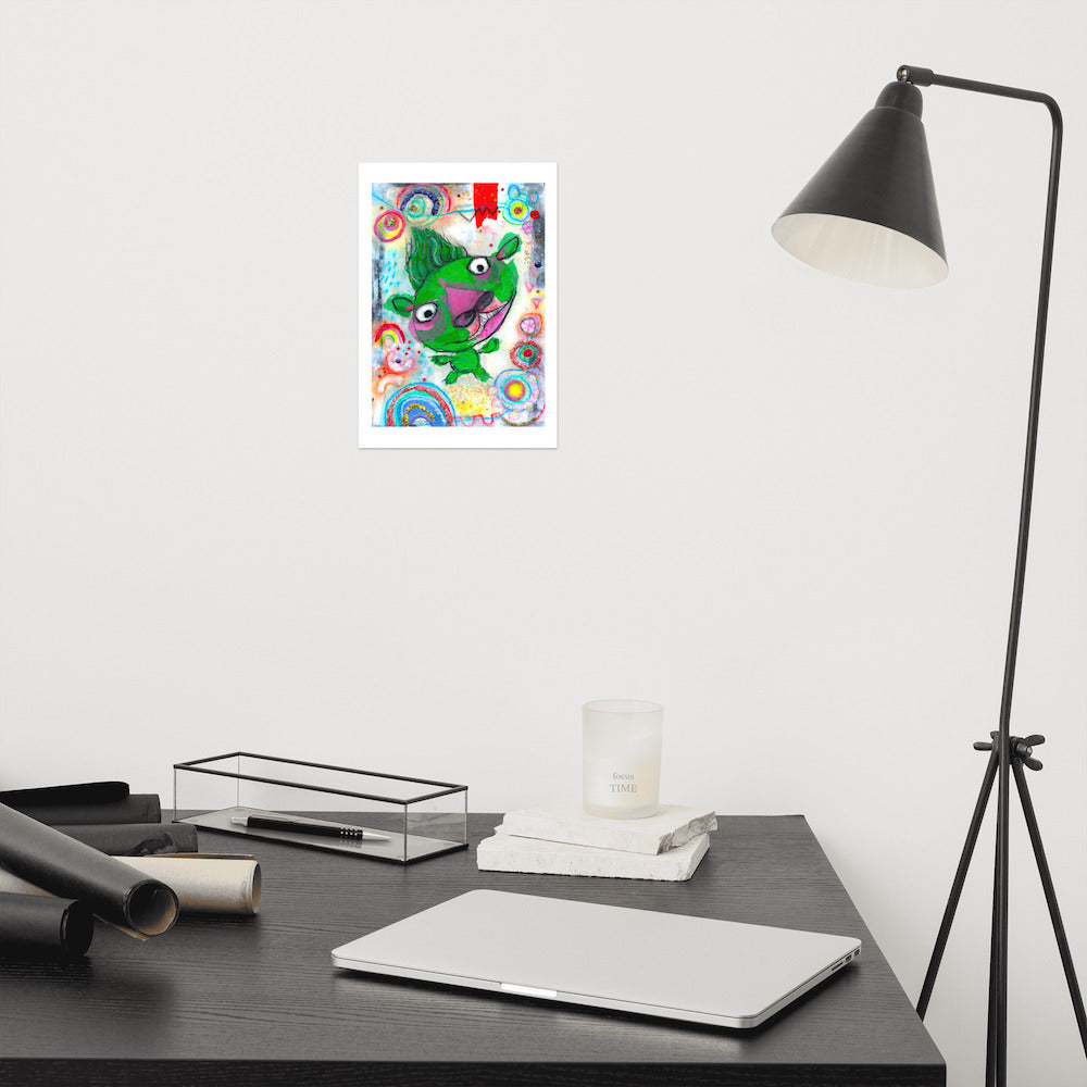 Colorful happy fine art print of a green monster smiling on vibrant background hanging on wall at modern desk area.