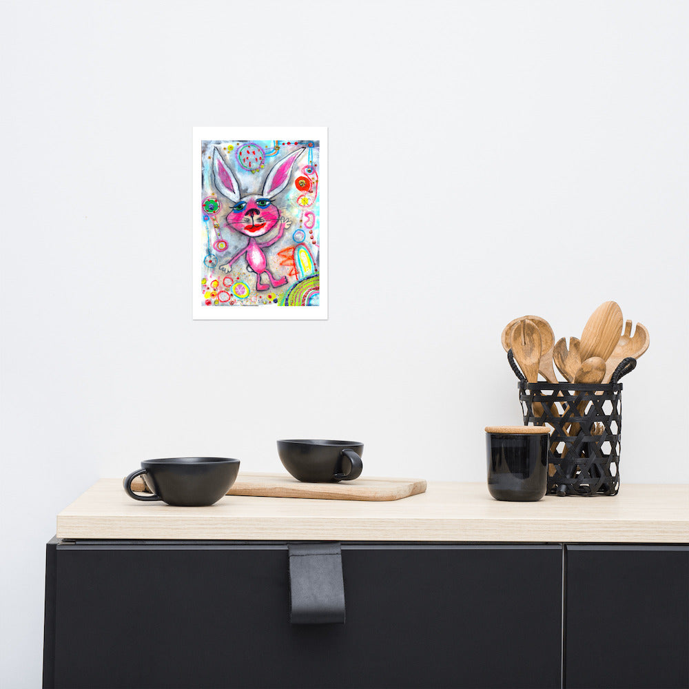 Colorful happy fine art print of a pink rabbit waving hello on vibrant background hanging on wall at stylish counter.