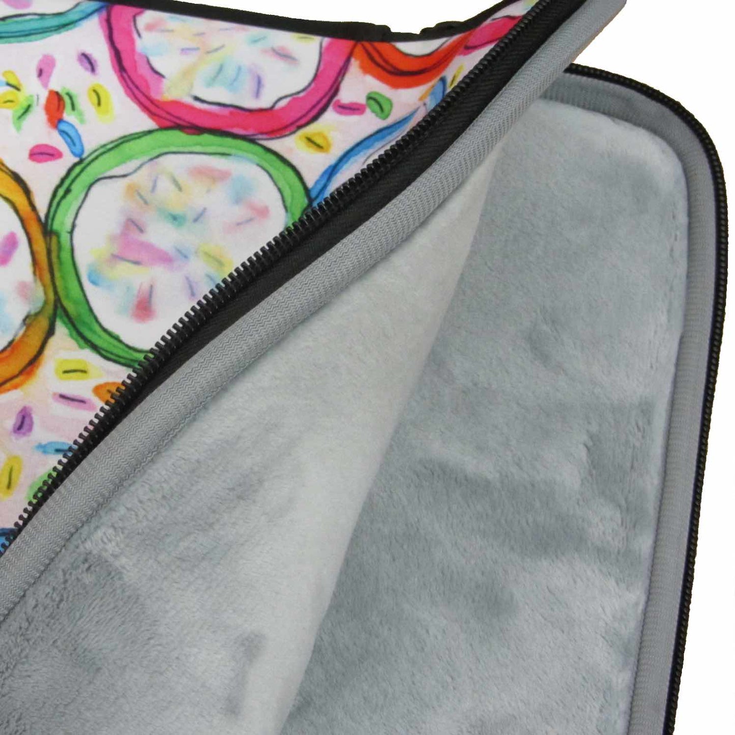 Graphic laptop case with rainbow-inspired multicolor print in Frosted Cookies. Detail of soft furry lining in gray color.