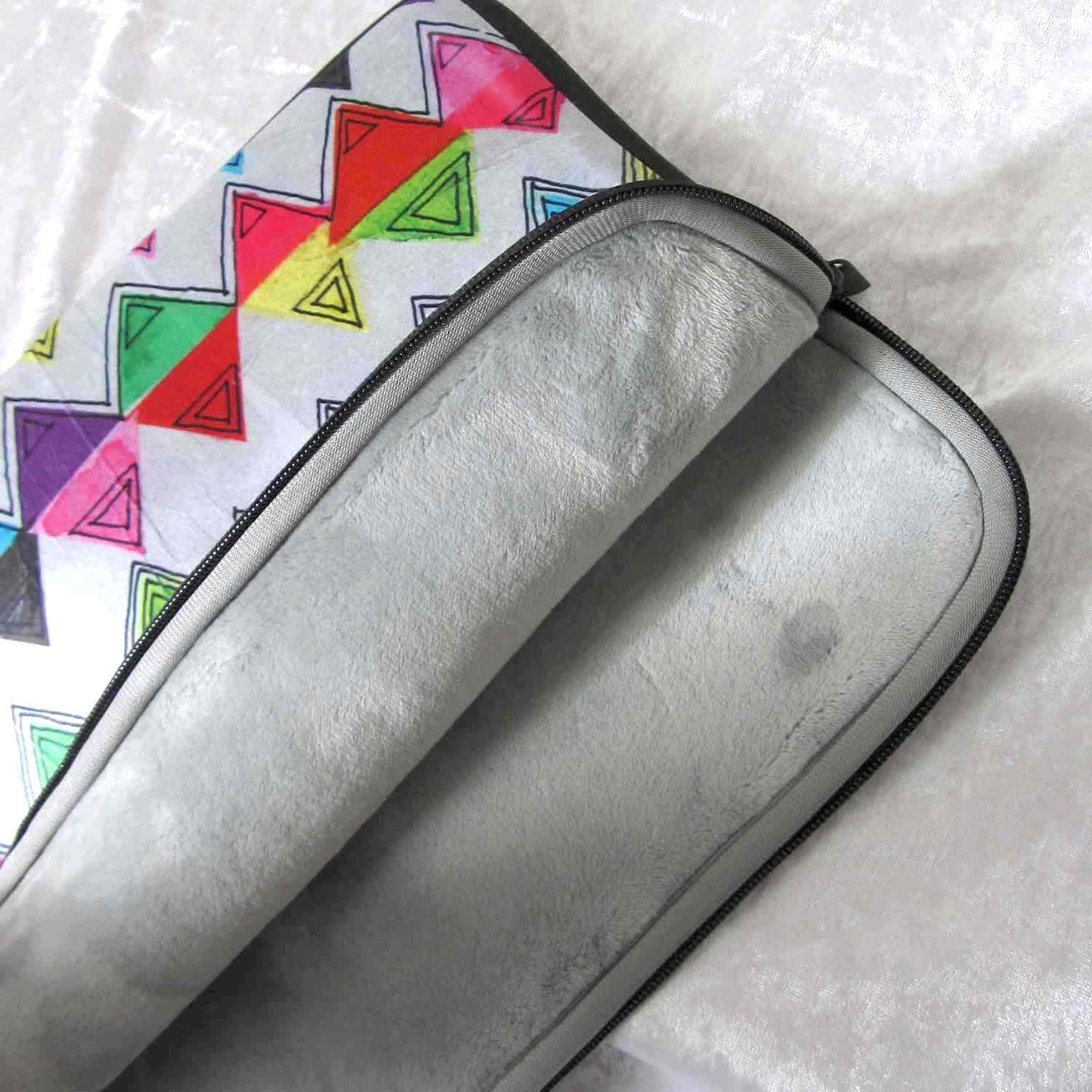 Detail of soft furry lining in gray color of graphic laptop case with rainbow-inspired multicolor print in Zigzag.