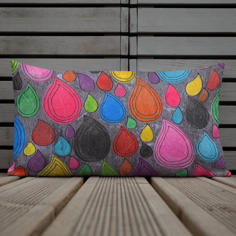 Vibrant, cheerful, and playful style accent pillow on wood deck with a multicolor graphic Dripdrop print on front.