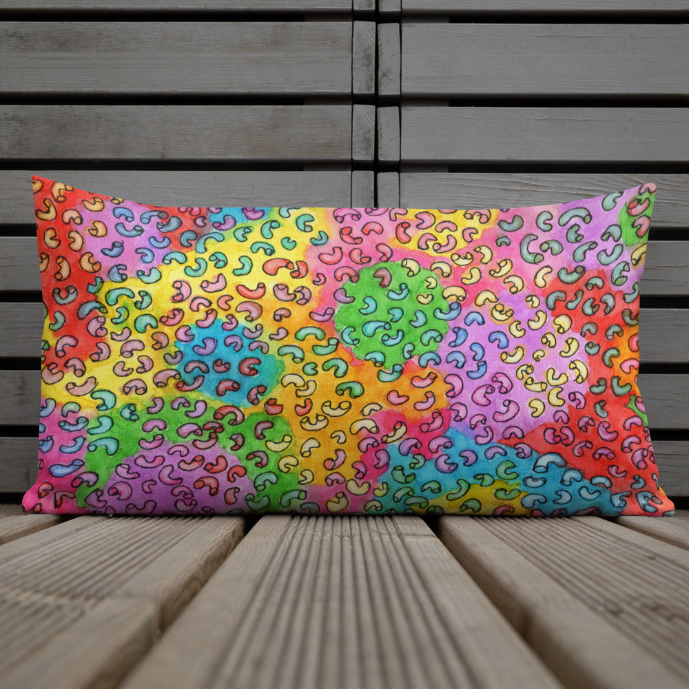 Vibrant, cheerful, and playful style accent pillow on wood deck with a multicolor graphic Macaroni print on front.