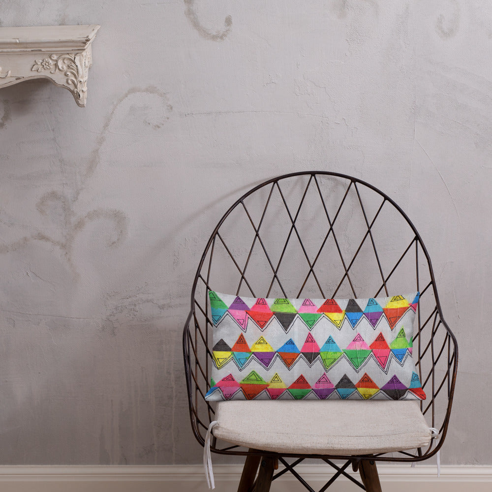 Vibrant, cheerful, and playful style accent pillow on modern chair with a multicolor graphic Zigzag print on front.